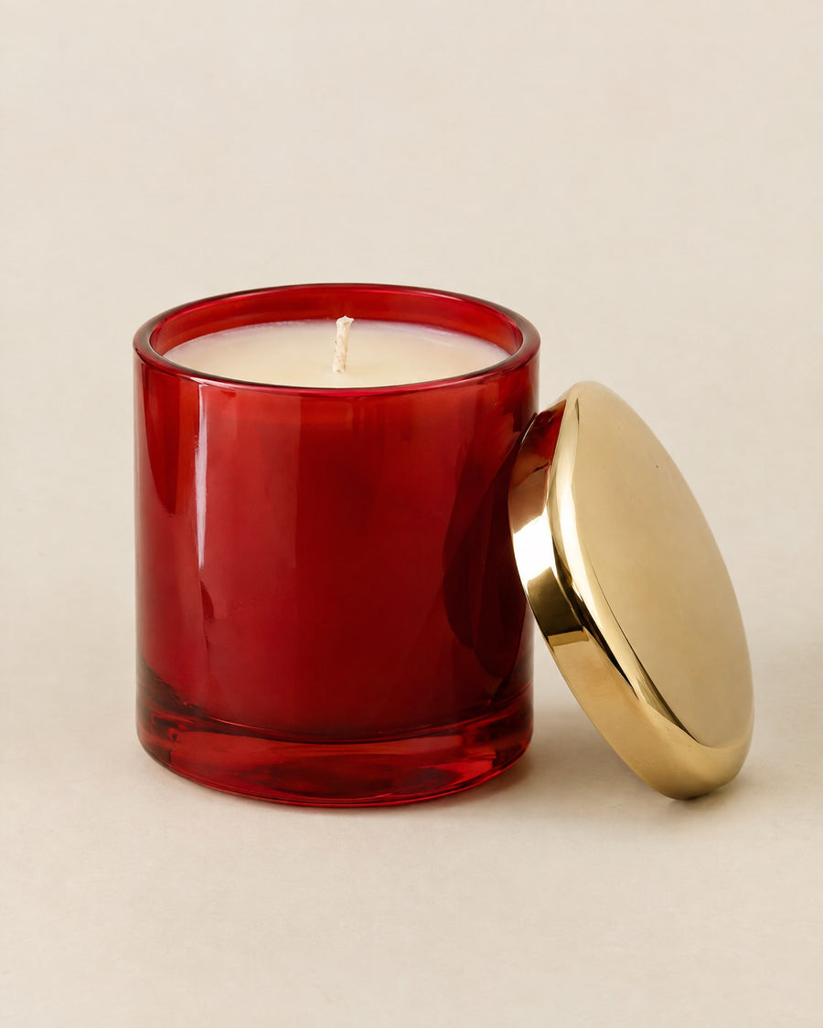 Bougie Le Dîner in a lacquer-red glass vessel with its gold lid