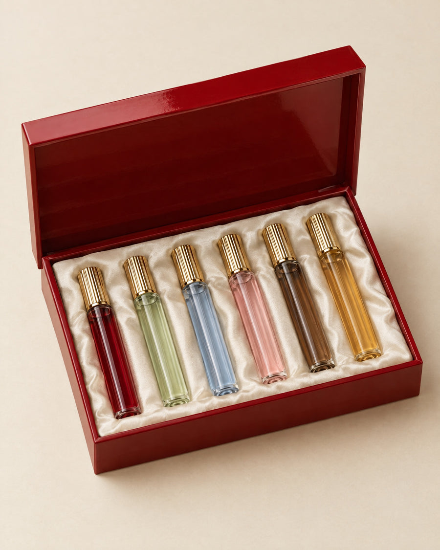 Le Coffret des Invités: six fragrance vials with gold caps in an open lacquer-red box