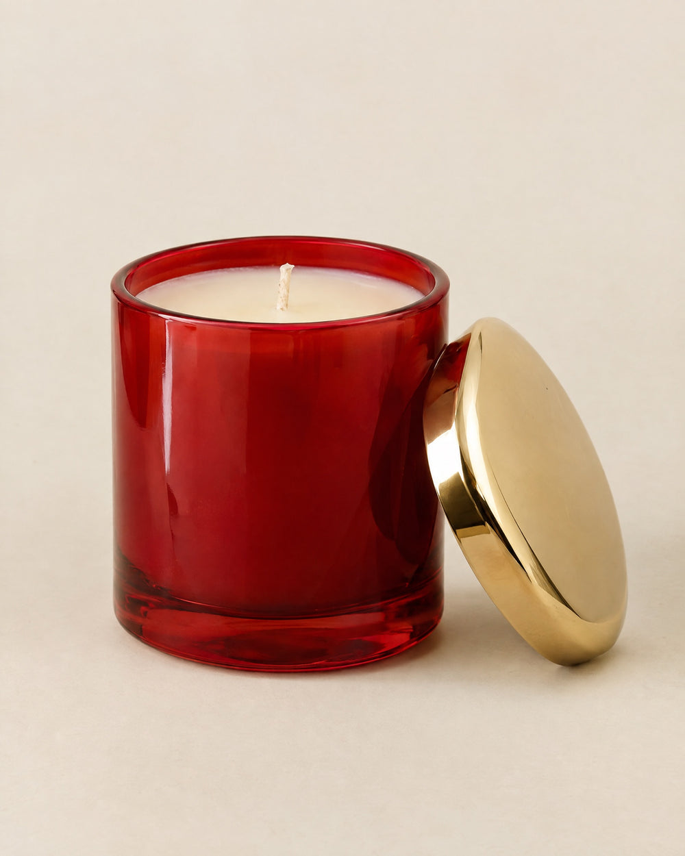 Bougie Le Dîner in a lacquer-red glass vessel with its gold lid