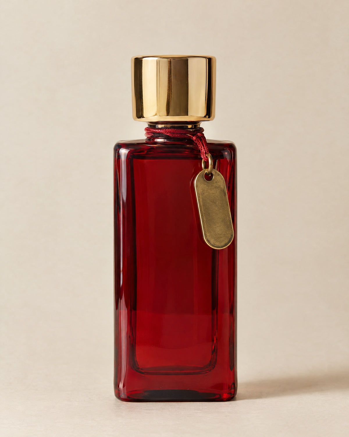 Chambre 12 eau de parfum in a tall cherry-red glass flacon with a mirror-gold cap and a brass key tag