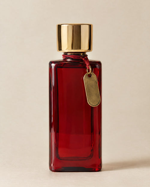 Chambre 12 eau de parfum in a tall cherry-red glass flacon with a mirror-gold cap and a brass key tag