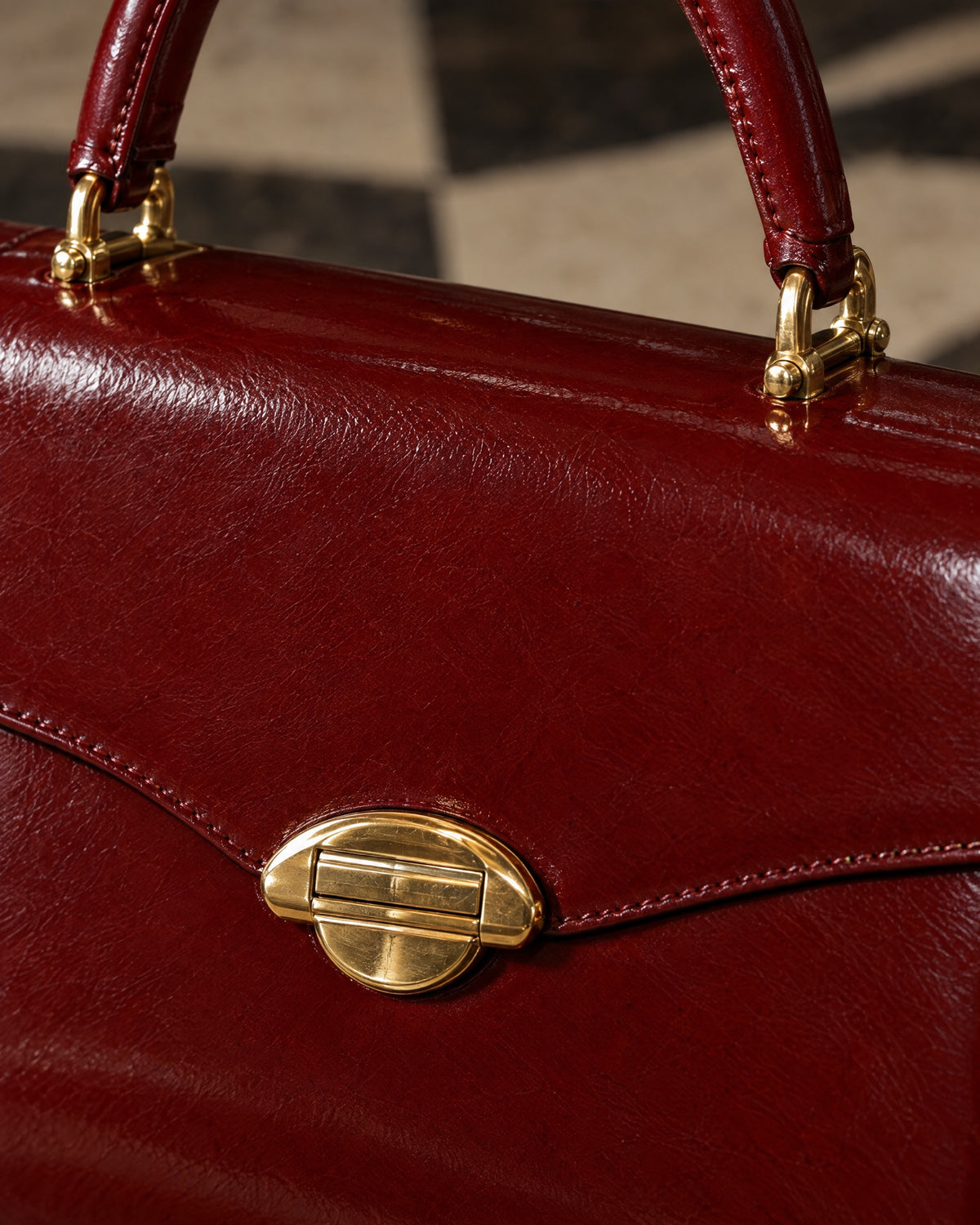 Close-up of the curved gold arch clasp and hand-stitched edges