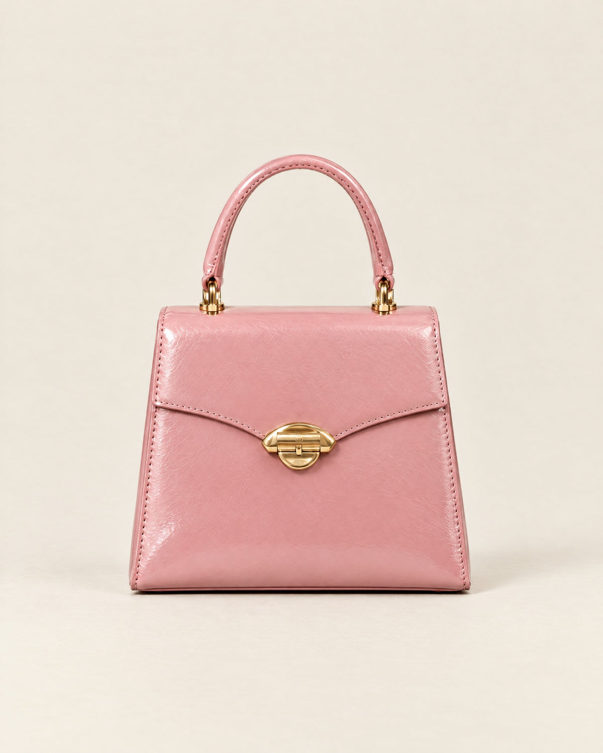 La Promenade Mini in peony-pink glazed calf with a gold arch clasp