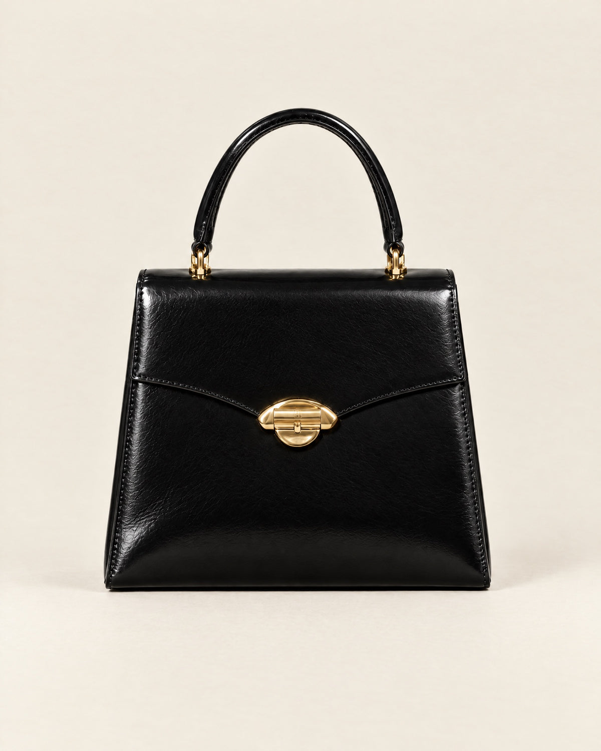 Le Cavalier top-handle bag in black glazed calf with a gold arch clasp