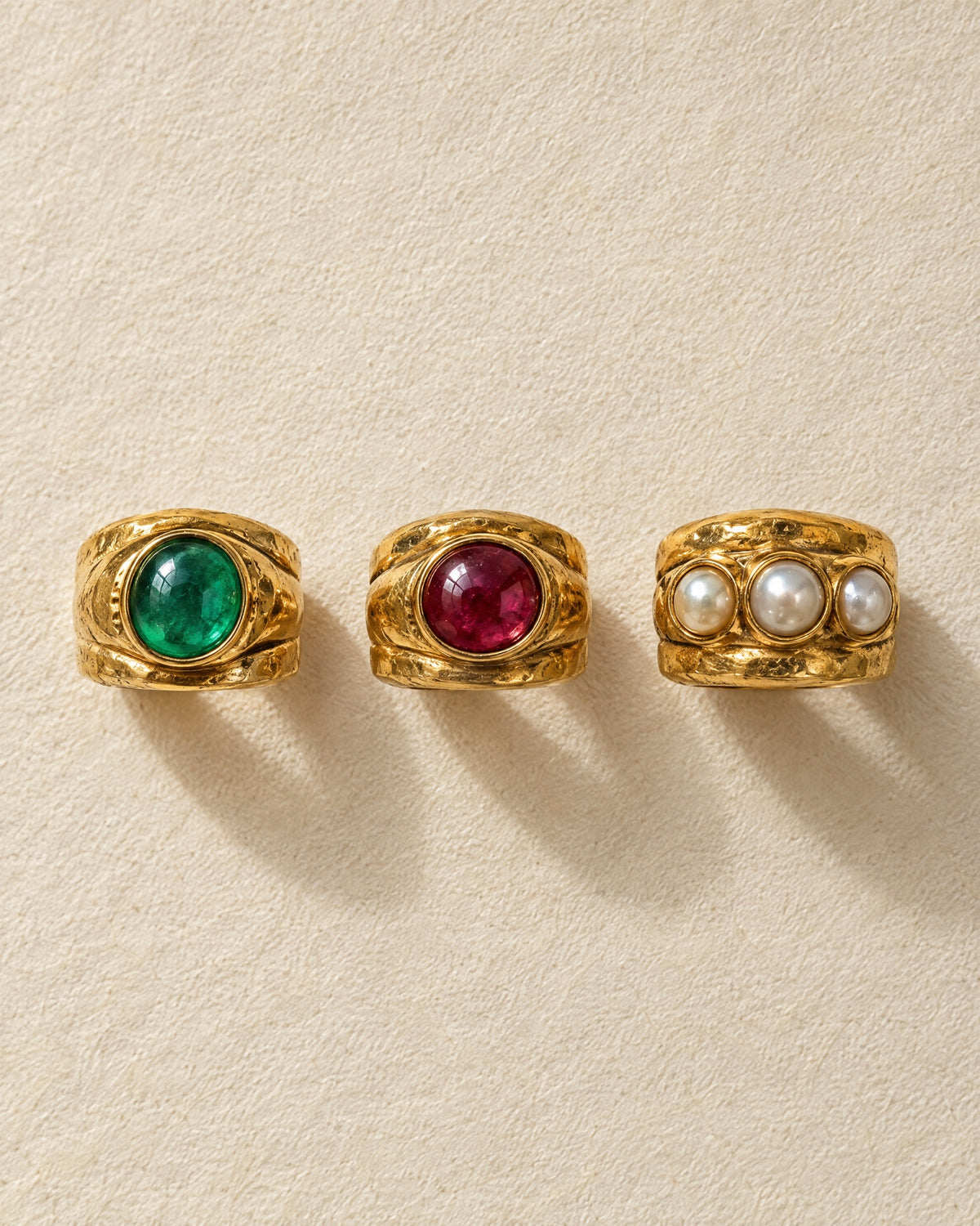 The three rings laid side by side on ivory paper