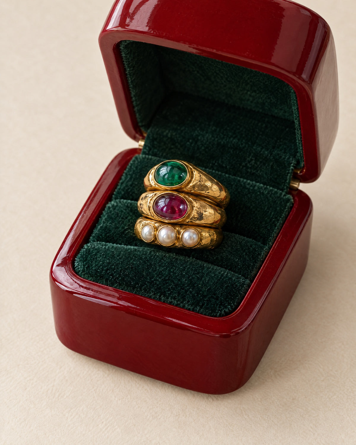 The stack in its lacquer-red ring box with a green velvet insert