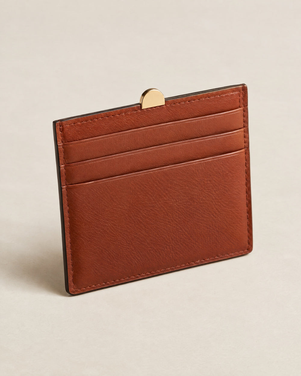 Porte-Cartes Brique card holder in brick-rust calf with a gold arch tab