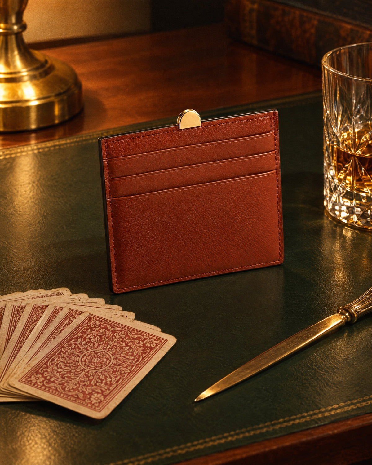 The card holder on a green leather desk blotter beside playing cards
